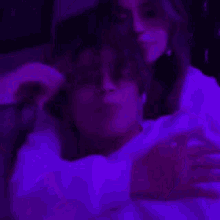a woman wearing fishnet stockings is laying on a bed with purple lights .