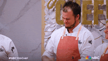 a man wearing a chef apron is standing in front of a sign that says chef