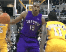 a man in a purple toronto jersey holds a basketball