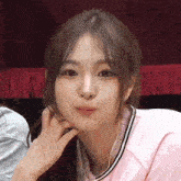 a close up of a girl making a funny face with her hand on her chin