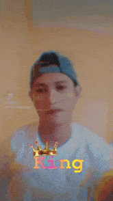a man wearing a baseball cap and a white shirt with the word king on it