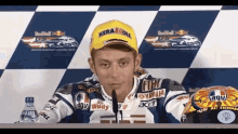 a motorcycle racer wearing a yellow hat with kerakoll on it