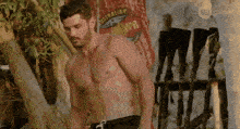 a shirtless man is standing in front of a flag that says australian