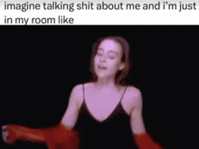 a woman in a black tank top is dancing in a room with a caption that says imagine talking shit about me