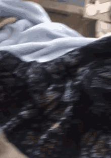 a blurry picture of a person laying in bed with a blue blanket