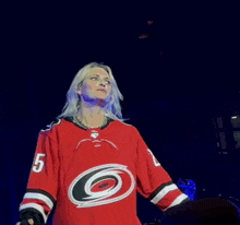 a woman is wearing a red jersey with the number 5 on it