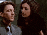 a man in a suit and tie talks to a woman