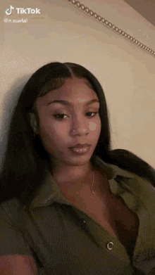a woman with a nose ring is wearing a green shirt
