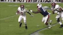 a football player wearing a number 55 jersey is running with the ball on a field .