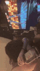 a woman is holding a jar with the number 11 on it in front of a tv screen