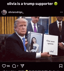 a picture of donald trump holding a picture of olivia