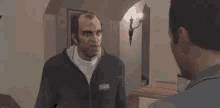 two men are standing next to each other in a room .