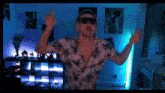 a man wearing sunglasses and headphones is dancing in a room with blue lights
