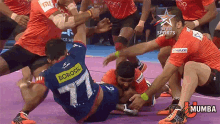 a group of men are playing a sport and one of them has the number 77 on his back