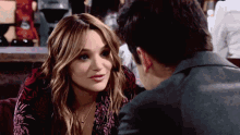 a man and a woman are looking at each other and smiling