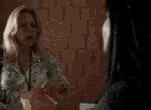 a blurry picture of two women standing next to each other .
