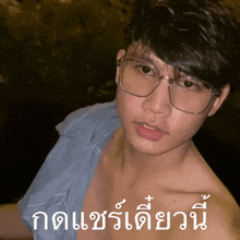 a man wearing glasses and a blue shirt has a foreign language written on the bottom of his face