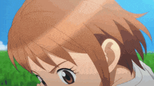 a close up of a girl 's face with a green field in the background