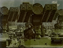 a group of military vehicles are lined up in a row and one of the vehicles has the letter x on the side