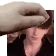 a hand is touching a man 's forehead in a pixel art .