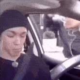 a man wearing a beanie is sitting in a car .