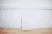 a french press is pouring coffee into a mason jar