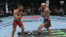 two men are fighting in a ufc ring and the scoreboard says oliveira