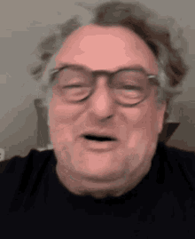 an older man wearing glasses and a black shirt is making a funny face