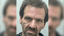 a man with a beard is looking at the camera and has a serious look on his face .