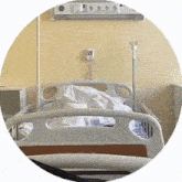 an empty hospital bed in a circle with a button on the wall that says " emergency "