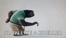 a stuffed animal of a sloth wearing a green shirt and khaki pants is walking with a cane .