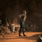 a woman is standing in a cave with her hands in her pockets