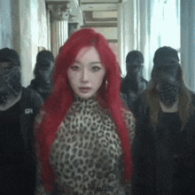 a woman with red hair is wearing a leopard print top and standing in a hallway with a group of people .