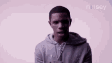 a young man is wearing a hoodie and a necklace .