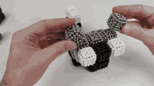 a person is holding a piece of black and white beadwork