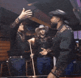 a man in a cowboy hat is hugging another man in a bar