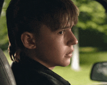 a close up of a young boy 's face in a car