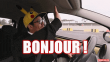 a man wearing a pikachu hat and glasses says bonjour in a car