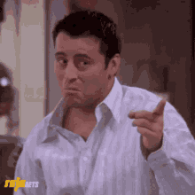 a man in a white shirt is pointing his finger at something .