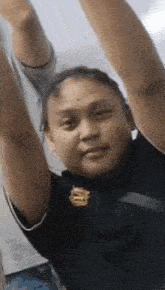 a woman with her arms in the air wearing a black shirt with a lion on it .