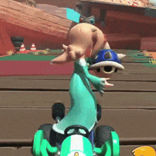 a cartoon character is riding a green go kart on a track .