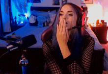 a woman with blue hair is wearing a shure microphone