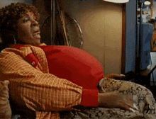 a woman with a large belly is sitting on a bed