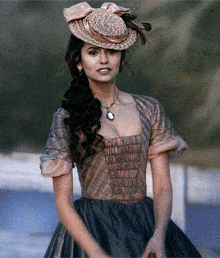 a woman wearing a straw hat and a dress with a necklace