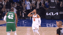 a basketball player wearing a number 42 jersey stands next to a basketball player wearing a number 11 jersey