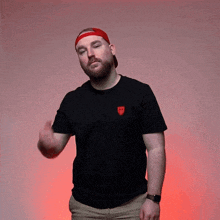 a man wearing a red hat and a black shirt with a red shield on the front