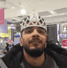 a man wearing a crown in front of a sign that says a