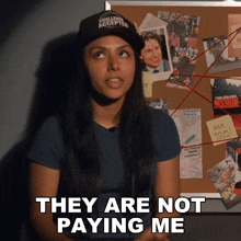 a woman says they are not paying me in front of a bulletin board