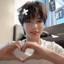 a young man making a heart shape with his hands