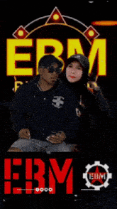 a man and a woman standing next to each other in front of a sign that says ebm